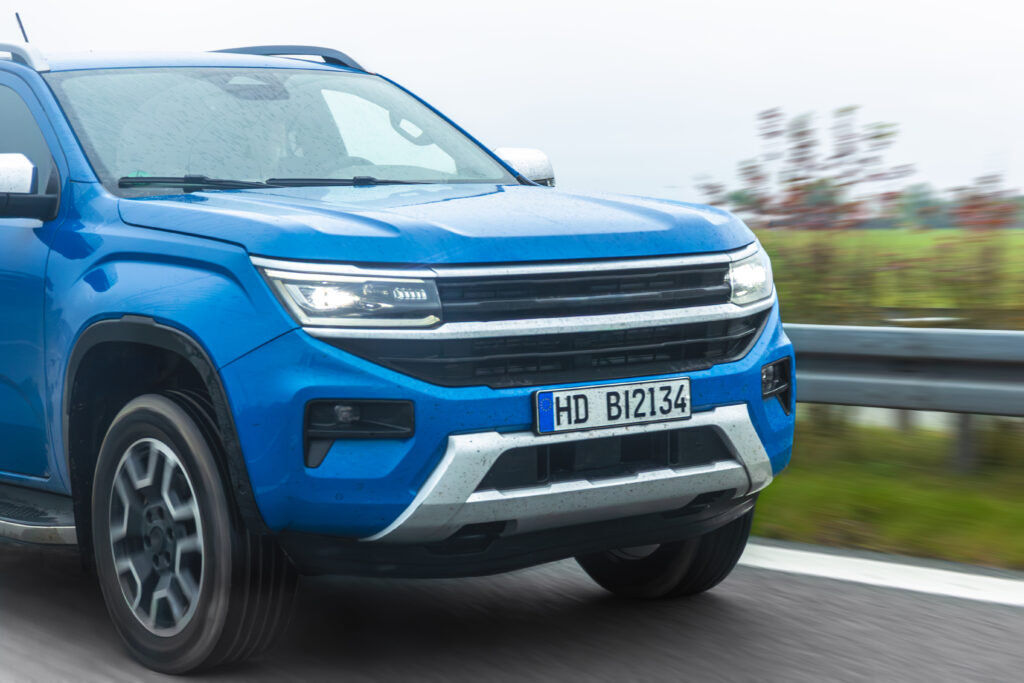 Picape azul em movimento na estrada molhada, representando a importância da manutenção de picapes para garantir segurança, desempenho e durabilidade do veículo.