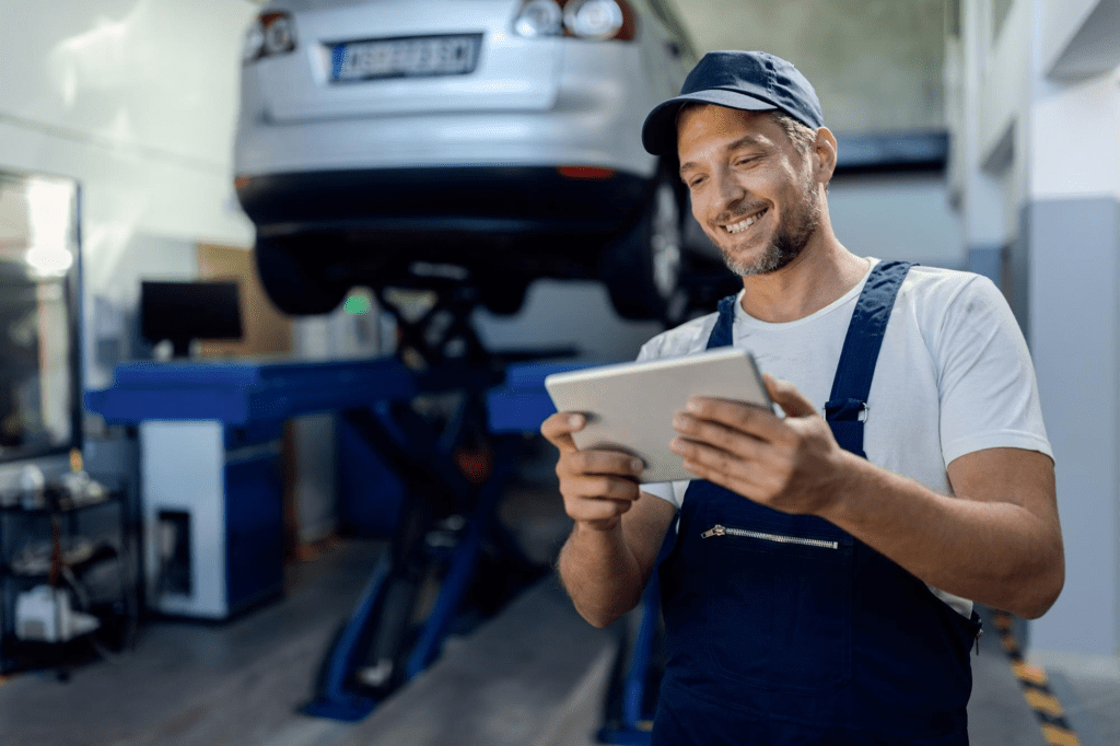 Mecânico sorrindo em oficina automotiva us